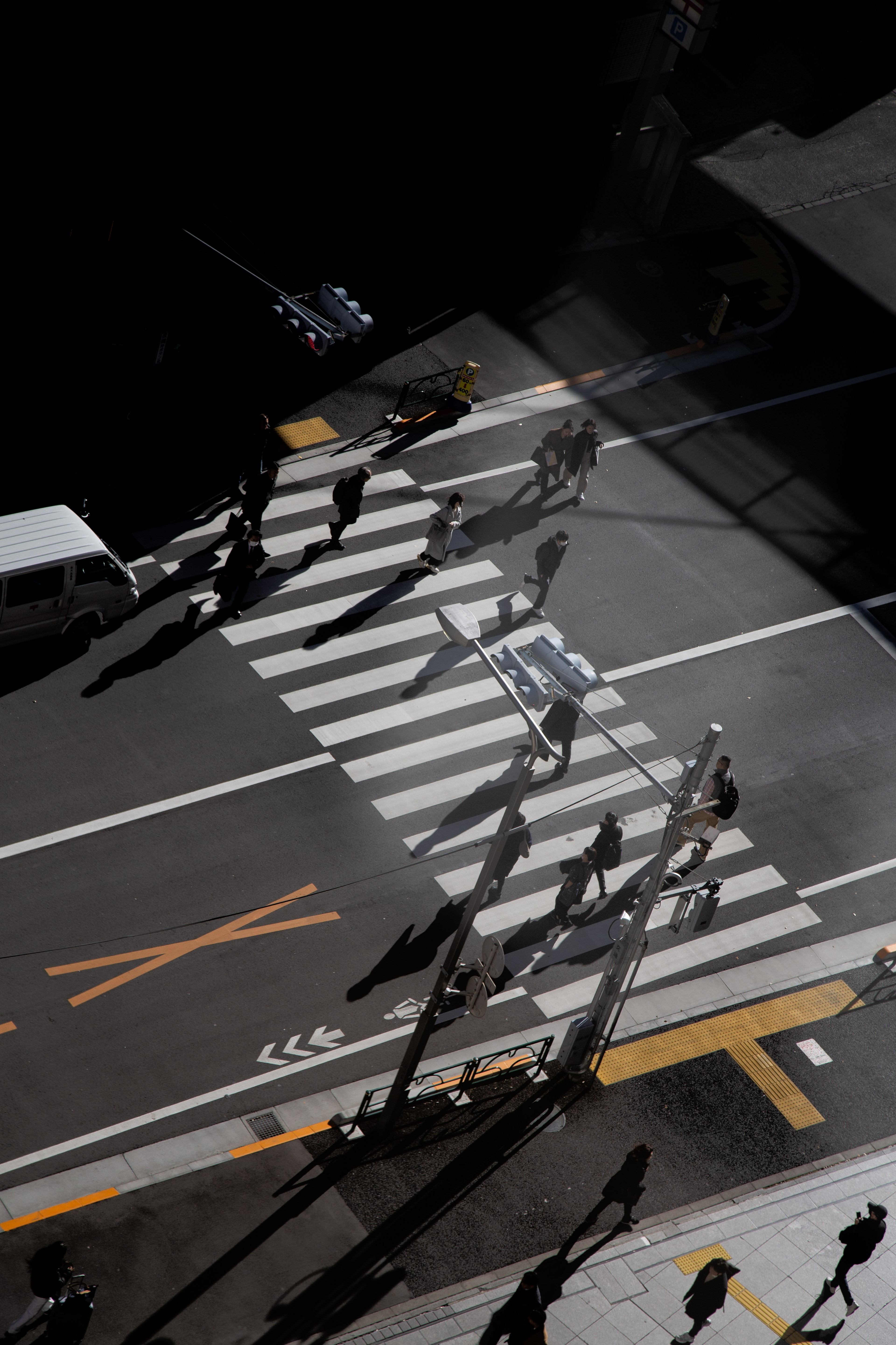 Pedestrians at a morning crosswalk seen from above